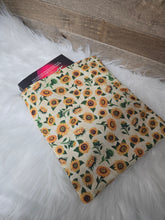 Load image into Gallery viewer, Floral-patterned book sleeve on a white fur surface with a wooden floor background