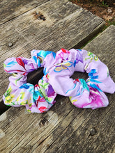 Load image into Gallery viewer, light purple scrunchie with multicoloured floral design on wood surface