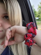 Load image into Gallery viewer, A person's forearm showcasing a red and blue berry patterned scrunchie hair accessory.