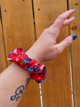 Load image into Gallery viewer, A person's forearm showcasing a red and blue berry patterned scrunchie hair accessory.