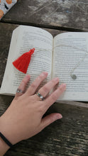 Load image into Gallery viewer, silver chain bookmark with red tassel on top of a book
