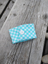 Load image into Gallery viewer, A blue and white checkered drink cozie placed on a wooden surface.