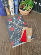 Load image into Gallery viewer, silver chain bookmark with red tassel on top of a book