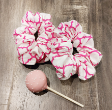 Load image into Gallery viewer, white scrunchie with pink lattice pattern on wood surface with cake pop