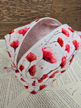 Load image into Gallery viewer, top view of cosmetic bag abstract red and pink poppy flower with black stem on white back ground with white zipper pale pink polka dot inner lining 
